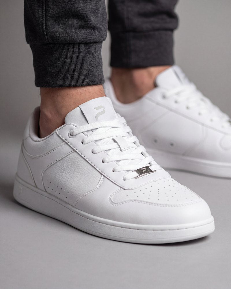 Flow 2 White dance sneakers in tumbled and smooth microfiber, worn with charcoal joggers on a gray floor